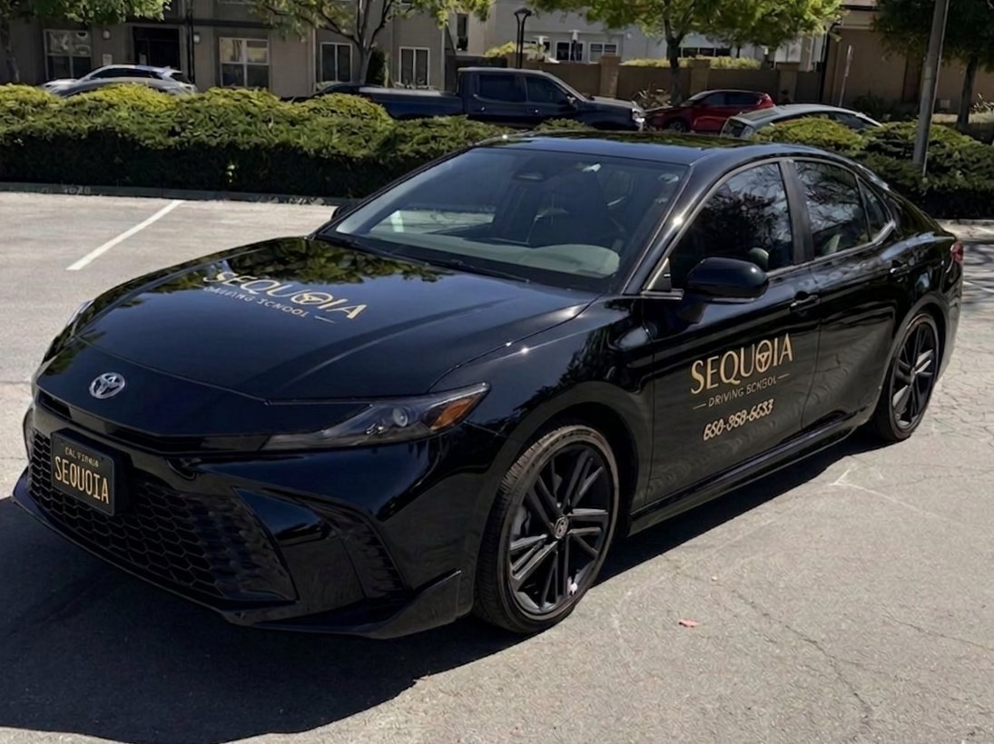Sequoia Driving School's black Toyota Camry training car with the gold logo on the door